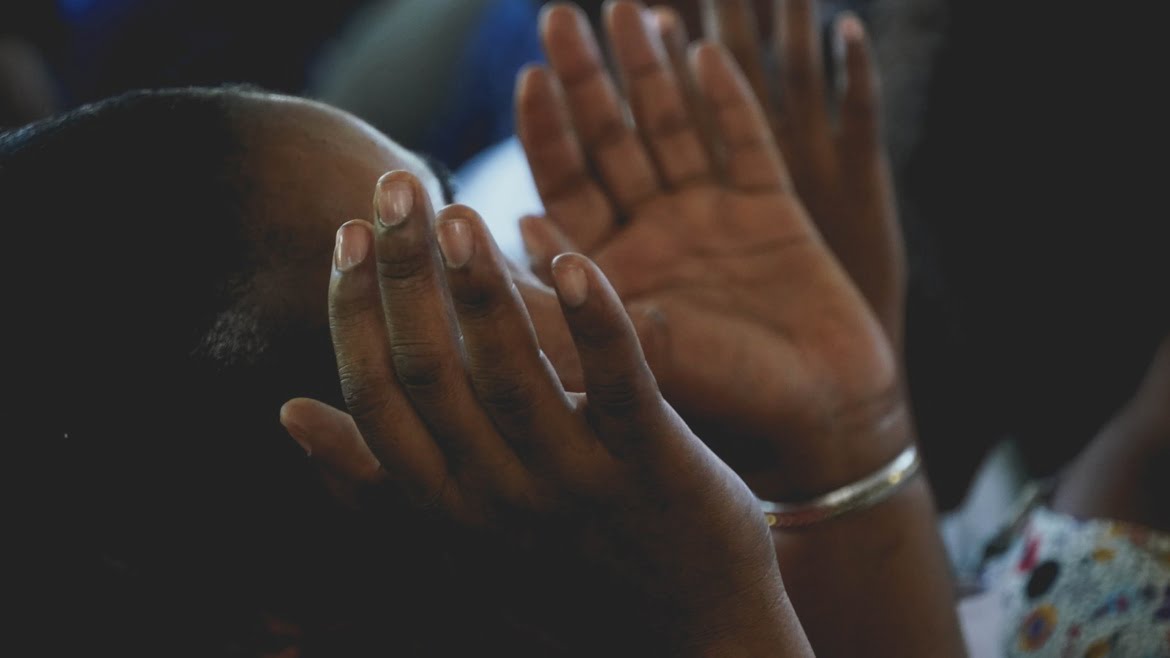 woman praying hands raised