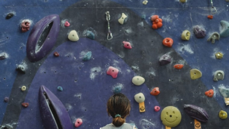 Woman preparing for climbing high on wall