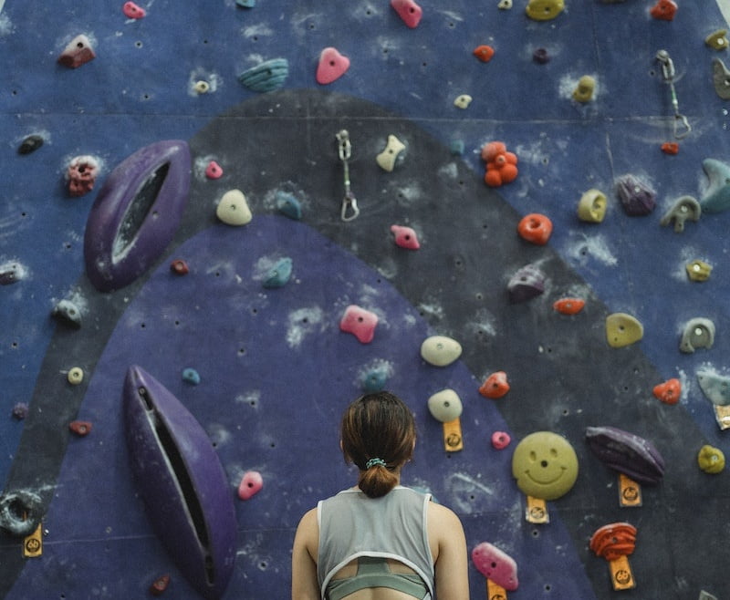 Woman preparing for climbing high on wall